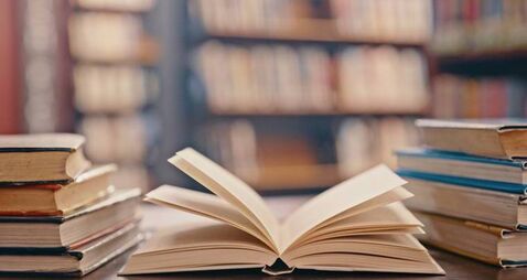 Library, books on table and background for studying, learning and research in education, school or college. Reading, philosophy
