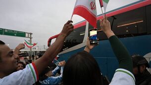 <p>Football fans cheer as Iran's players leave the Tijuana International Airport on a bus ahead of the World Cup. Pic: Guillermo Arias / AFP via Getty Images</p>
