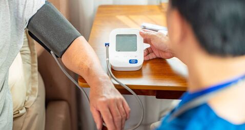 Doctor examine senior man patient at home.