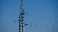 High-voltage power transmission tower against clear sky