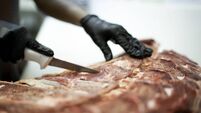 Female hands cutting a piece of ribs in a butchers shop