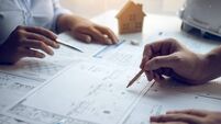 Engineering man showing blueprint detail for people buying house.