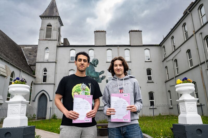 (Left to right) Aaser Shaaban and Daniel McCarthy outside Rochestown College holding their Leaving Certificate French exam papers. Picture: Chani Anderson