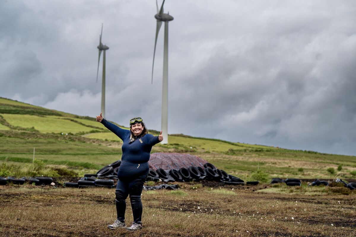 Wetsuit-clad and windswept beneath the turbines on the Iveragh Peninsula, Julia Galvin stands proud, a champion bog snorkeller with a message of embrace the madness of life, and live it boldly as you only get one. Picture: Chani Anderson Wetsuit-clad and windswept beneath the turbines on the Iveragh Peninsula, Julia Galvin stands proud, a champion bog snorkeller with a message of embrace the madness of life, and live it boldly as you only get one. Picture: Chani Anderson