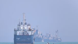 A small motorboat passes anchored vessels in the Strait of Hormuz (Amirhosein Khorgooi/ISNA/AP)