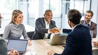 Happy businessmen shaking hands on a meeting in the office.