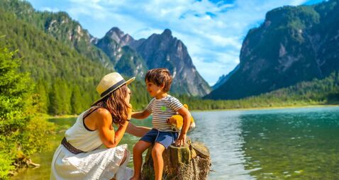 Mother and son enjoying summer vacation at lake dobbiaco in the dolomites