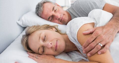Couple sleeping and spooning in bed