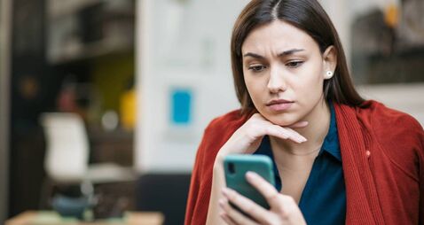 Close up of a sad young Caucasian woman reading bad news