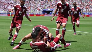 <p>Boualem Khoukhi of Qatar celebrates with teammates after scoring a late late equalier. Picture: Emilee Chinn/Getty</p>