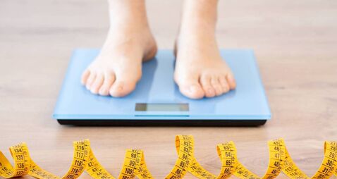 woman measuring her weight on the scale