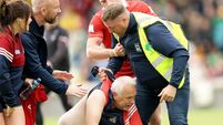 A steward tackles a Cork fan on the pitch after the game 13/6/2026