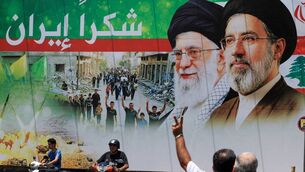 <p>A motorcyclist in the southern suburbs of Beirut, Lebanon, flashes a victory sign as he passes a banner that reads 'Thank you Iran' following a deal between the US and Iran. Picture: Mohamed Azakir/Reuters</p>