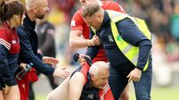 A steward tackles a Cork fan on the pitch after the game 13/6/2026