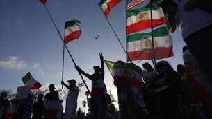 <p>IRAN AWAY: People wave pre-revolutionary Iranian flags during a protest outside Los Angeles Stadium. Pic: AP Photo/Ty ONeil.</p> <p>IRAN AWAY: People wave pre-revolutionary Iranian flags during a protest outside Los Angeles Stadium. Pic: AP Photo/Ty ONeil.</p>