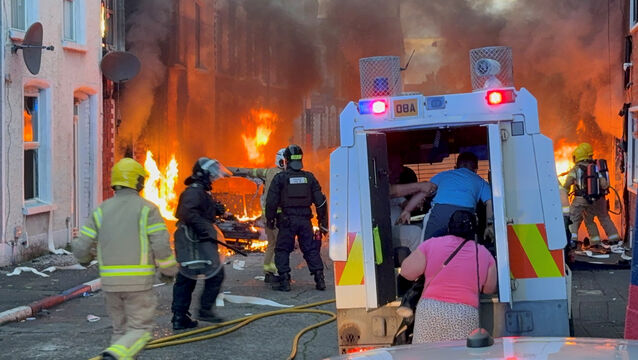 <p>A family get into a PSNI vehicle after being rescued from houses which caught fire in Lendrick Street in east Belfast after disorder flared last week in the city. </p>