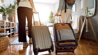 Unrecognizable couple arriving at the accommodation with their suitcases