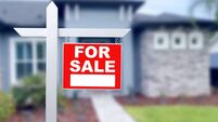 Home For Sale Real Estate Sign and Beautiful New House.