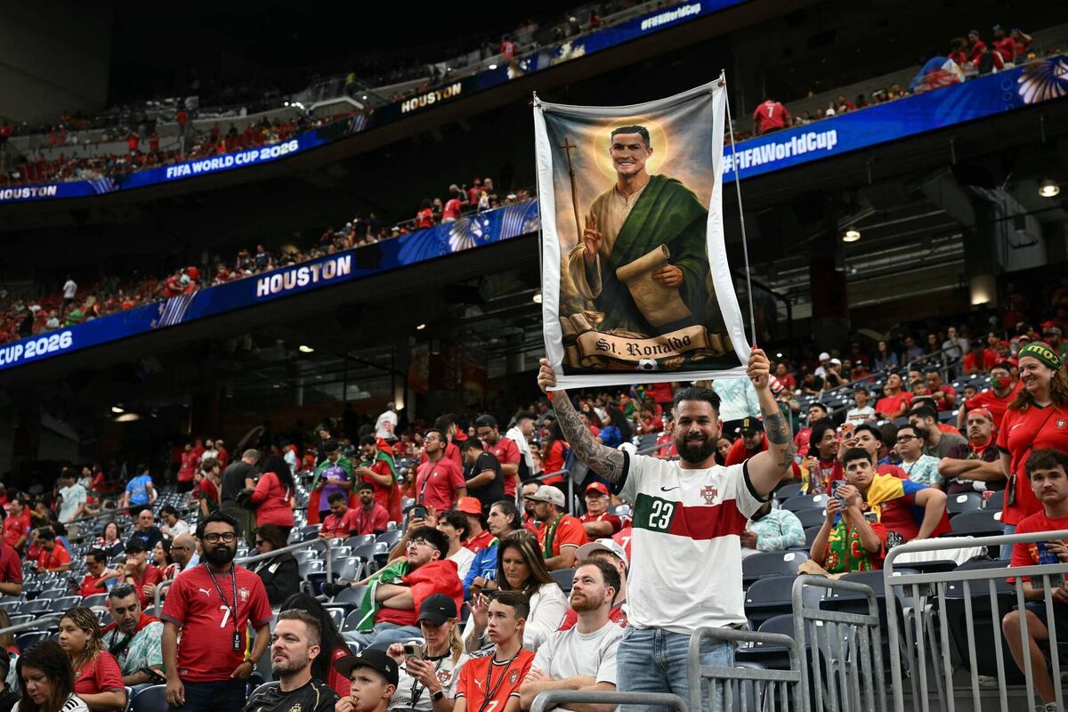 THE SAINT: A Portugal supporter poses with banner depicting Cristiano Ronaldo as a Saint. Pic: Ronaldo Schemidt/Getty THE SAINT: A Portugal supporter poses with banner depicting Cristiano Ronaldo as a Saint. Pic: Ronaldo Schemidt/Getty