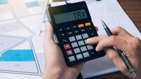iStock-1399111301.jpg Man holding a calculator calculating land sales tax and document management of land purchases. The concept for residential const