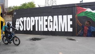 <p>A Deliveroo rider passes the new Lamine Yamal mural outside Bohemians' Dalymount Park, which features the Barcelona star with a Palestinian flag and the words "stop the game", referencing calls to halt the Ireland v Israel European cup fixture. Picture date: Monday May 18, 2026.</p> <p>A Deliveroo rider passes the new Lamine Yamal mural outside Bohemians' Dalymount Park, which features the Barcelona star with a Palestinian flag and the words "stop the game", referencing calls to halt the Ireland v Israel European cup fixture. Picture date: Monday May 18, 2026.</p>
