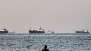 <p>A person stands on shallow water as cargo and commercial vessels are anchored in the Strait of Hormuz off Bandar Abbas, Iran, Monday, June 8, 2026. (Amirhosein Khorgooi/ISNA via AP)</p>
