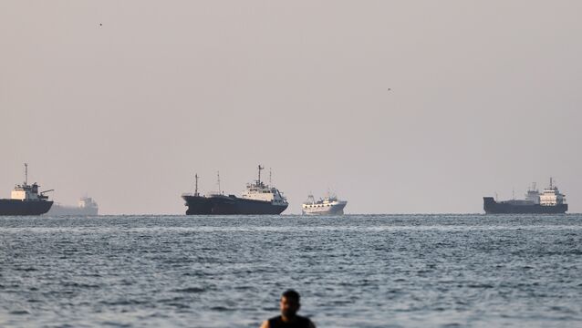 <p>A person stands on shallow water as cargo and commercial vessels are anchored in the Strait of Hormuz off Bandar Abbas, Iran, Monday, June 8, 2026. (Amirhosein Khorgooi/ISNA via AP)</p>