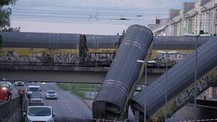Two good wagons of a freight train lying on a road (Ehsan Monajati/dpa/AP)