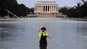 Members of the National Park Service clean algae from the Lincoln Memorial Reflecting Pool (Rahmat Gul/AP)