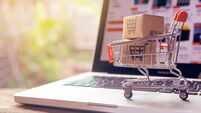 Shopping online concept - Parcel or Paper cartons with a shopping cart logo in a trolley on a laptop keyboard. Shopping service