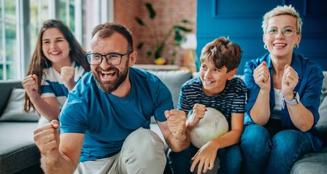 iStock-2228639082 (1).jpg Family enjoys an exciting soccer match together at home, celebrating every goal with joy and enthusiasm