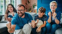 Family enjoys an exciting soccer match together at home, celebrating every goal with joy and enthusiasm