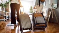 Unrecognizable couple arriving at the accommodation with their suitcases