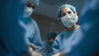 Hispanic medical professional doctor nurse looking serious towards colleagues during surgery operation procedure in hospital