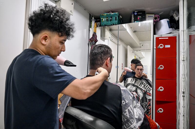 A volunteer gives a service user a haircut. A volunteer gives a service user a haircut.