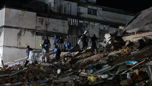 Rescue workers search through the rubble of a collapsed building after an earthquake in Caracas(Javier Campos/AP)