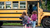 Children Boarding a School Bus on a Rainy Day With Backpacks
