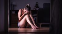 Victim of sexual harassment, domestic violence or abuse. Young sad woman crying and sitting on the floor at home. Ashamed, scare