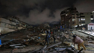 Rescue workers search through the rubble in Caracas (Javier Campos/AP)