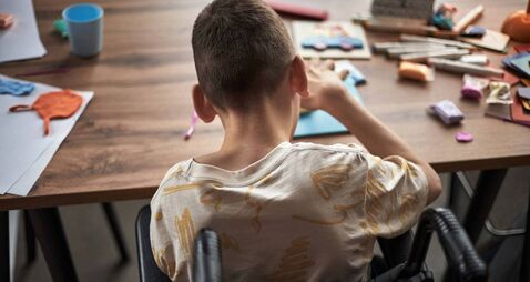 Child with Disability Engaged in Arts and Crafts Activity Sitting in Wheelchair