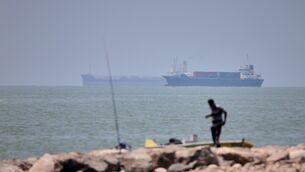 <p>A man stands beside a fishing pole along the shore as cargo ships and commercial vessels are seen in the Strait of Hormuz off Bandar Abbas, Iran, Wednesday, June 17, 2026. (Amirhosein Khorgooi/ISNA via AP)</p>