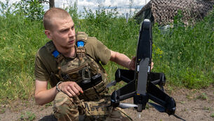 A Ukrainian serviceman of Khartia brigade launches a drone (Andrii Marienko/AP)