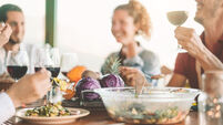 Happy friends eating vegetarian food and drinking red wine - Vegan family dining fresh vegetables in farmhouse