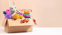 Toys for children in a box ready for donation on beige, copy space. Concept of toys donations, charity for children