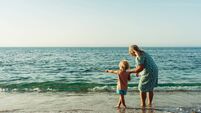 grandmother walks with her grandson on the beach on the sand by the sea