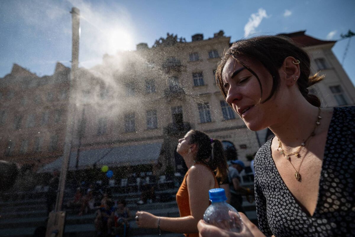Women cool off under a water spray on the Royal Castle Square in Warsaw's Old Town on Sunday. Picture: Wojtek Radwanski / AFP via Getty Images