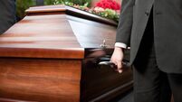 Funeral with casket carried by coffin bearer