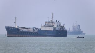 <p>A small motorboat passes anchored vessels in the Strait of Hormuz off Bandar Abbas</p>
