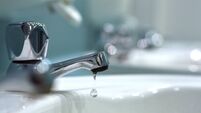 Closeup of Water Drop from Tap in Public Bathroom