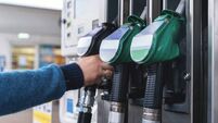 Refueling at a modern gas station with green fuel pumps and a customer filling their vehicle in a well-lit, organized space duri